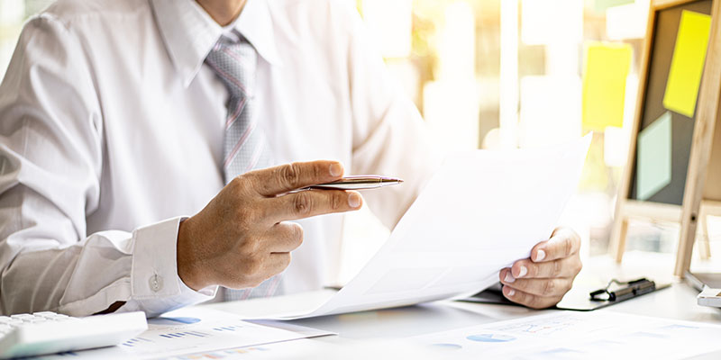 Close-up shot of a chief finance officer reviewing the company's financial chart documents.