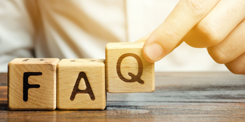 Businessman puts wooden blocks with the word FAQ to illustrate FAQs on ESR.