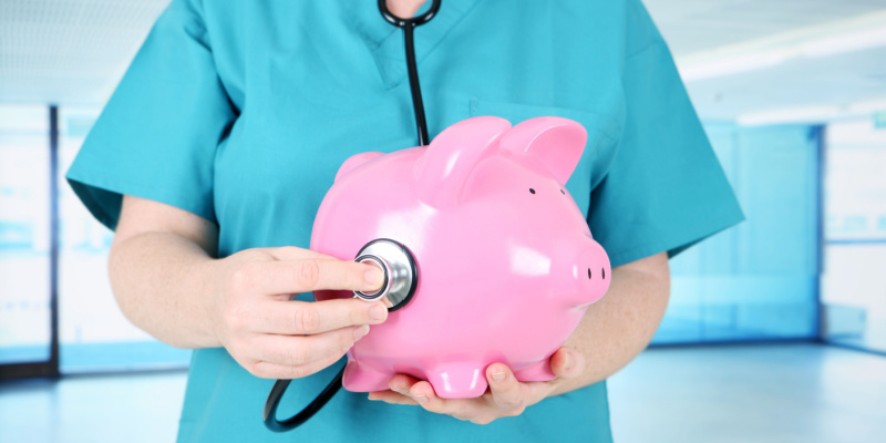 The image of a healthcare worker with a piggy bank illustrates the advantages of conducting a financial health check for your business.